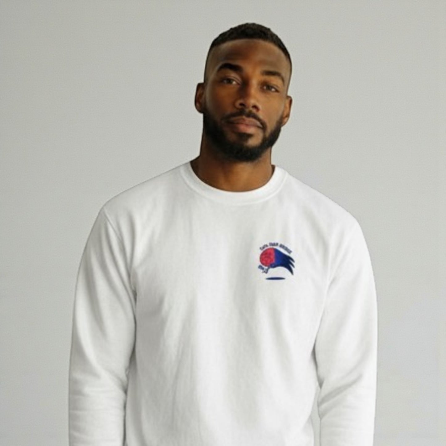 Man wearing a white long-sleeve shirt with a logo on a gray background