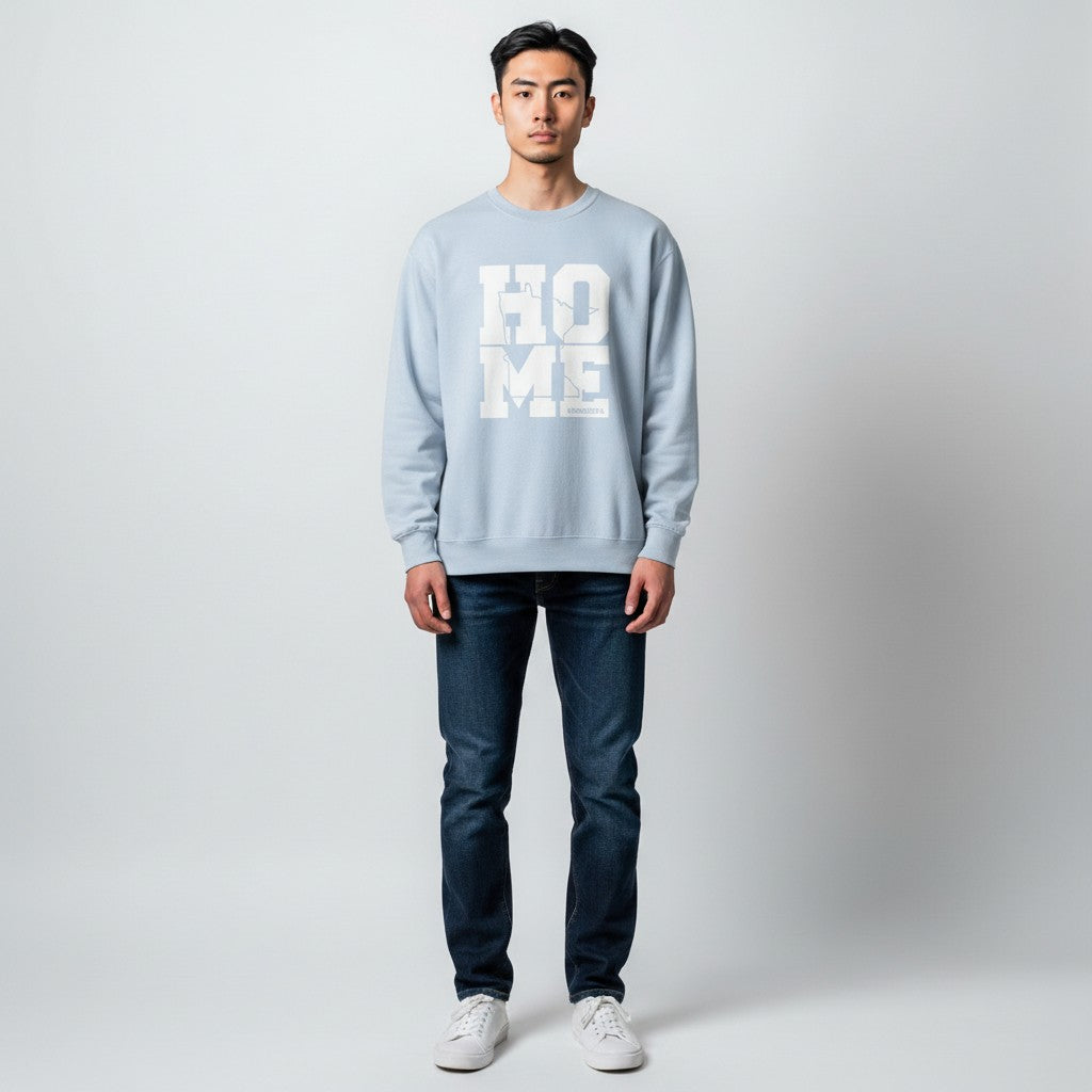 Person wearing a light blue sweatshirt with 'HOME' text on a plain background