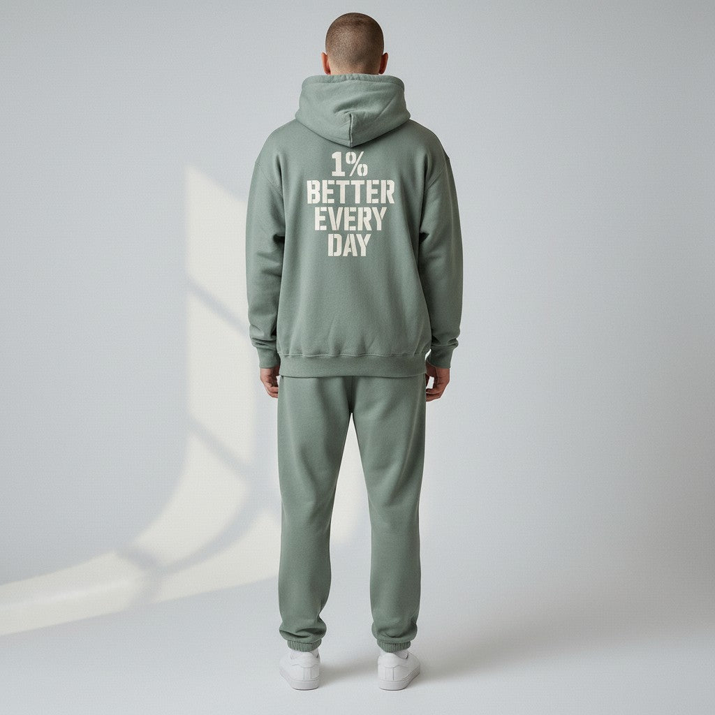 Person wearing a green tracksuit with '1% Better Every Day' text on the back against a light gray background