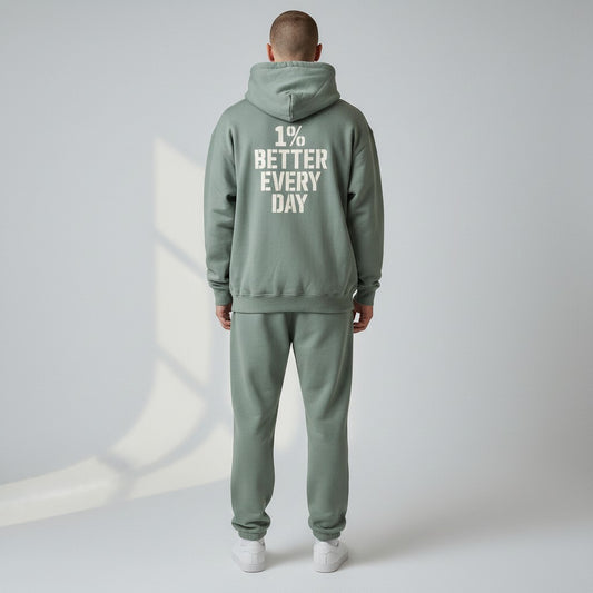 Person wearing a green tracksuit with '1% Better Every Day' text on the back against a light gray background